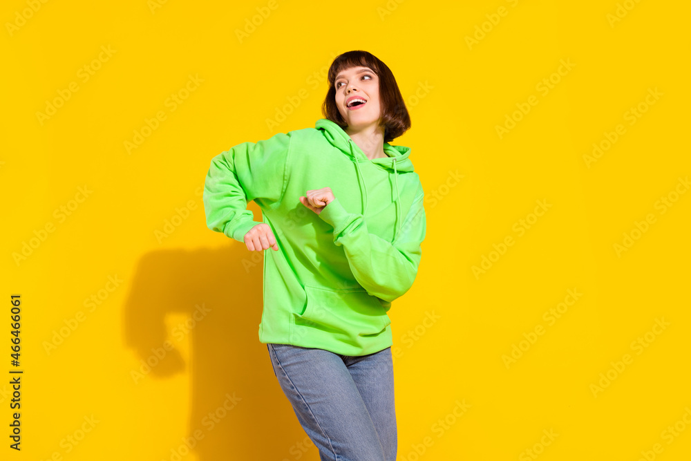 Sticker Portrait of attractive cheerful girl dancing moving holiday pastime celebrating isolated over bright yellow color background