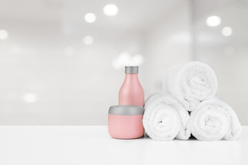 Spa still life with towels and skincare cosmetics against blurred background