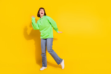Full length body size view of attractive cheerful girl dancing having fun copy space isolated over bright yellow color background