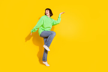Fototapeta na wymiar Full length body size view of attractive cheerful girl dancing having fun copy space isolated over bright yellow color background