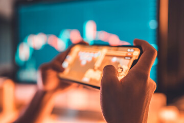 Close-up - Hands of woman playing blockchain nft game in mobile phone on price chart digital exchange background, Play to earn cryptocurrency rewards. © oatawa