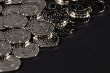 Silver coins on dark background. Ukrainian 10 hryvnias coins. Money and finances. Ukrainian coins.