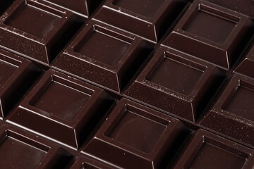 Close up a chocolate bar background. Chocolate bar cubes macro
