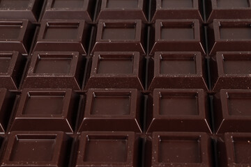 Close up a chocolate bar background. Chocolate bar cubes macro