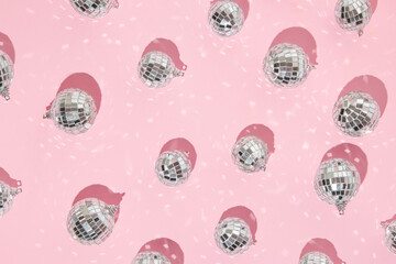 Christmas and New Year creative layout with disco ball decoration on pastel pink background. 80s or...