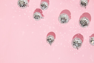 Christmas and New Year creative layout with disco ball decoration on pastel pink background. 80s or...