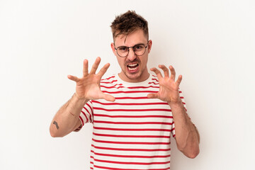 Young caucasian man isolated on white background showing claws imitating a cat, aggressive gesture.