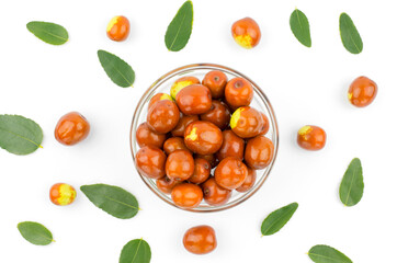 Bowl with ripe jojoba fruits on a white background. Chinese date fruit and green leaves on white background