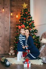 Mother and daughter celebrating christmas and new year near christmas tree