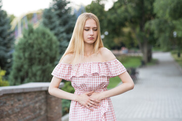 Fototapeta premium Portrait of a young and attractive caucasian girl who has a stomach ache