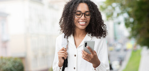 Young beautiful woman using smartphone in a city panoramic banner, Smiling student girl texting on her mobile phone, Modern lifestyle, connection, business concept