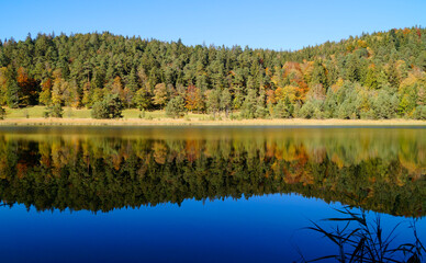 a scenic view of emerald-green lake Ober See near lake Alatsee on a fine autmn day in Bad Faulenbach (Fuessen, Bavaria in Germany)	