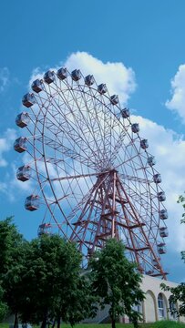 Ferris wheel on a blue sky background. Vertical frame
