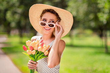 Photo of young happy joyful positive woman dream lady summer sun hold hands tulips wear glasses outside outdoors park