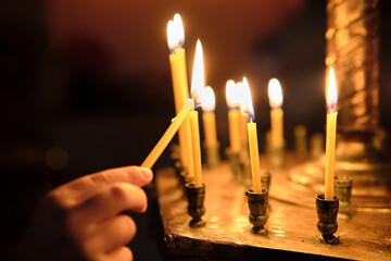 Little Boy lighting a church candle.