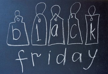 drawing with chalk on a black school board. black friday tags with the inscription black friday. banner