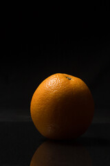 Vertical photo of an orange on a dark background