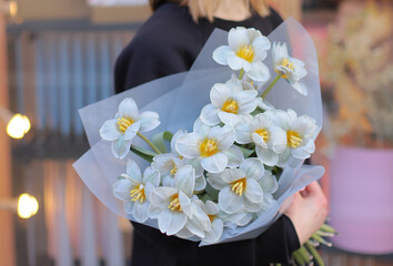 Young woman florist holding big beautiful blossoming mono bouquet of blue tulips flowers