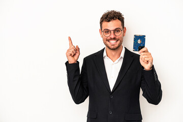 Young caucasian computerized holding HDD isolated on white background smiling and pointing aside, showing something at blank space.