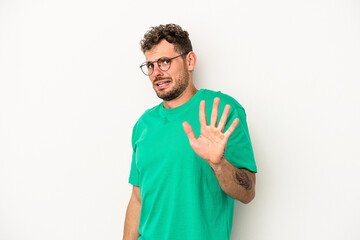 Young caucasian man isolated on white background being shocked due to an imminent danger