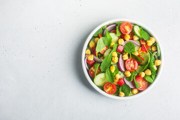 Top view of chickpea salad prepared with tomatoes and cucumber, copy space
