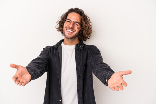 Young caucasian man isolated on white background showing a welcome expression.