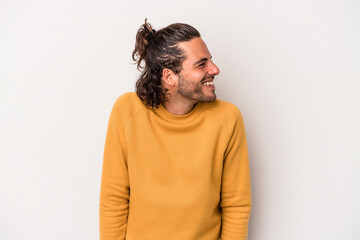 Young caucasian man isolated on gray background laughs and closes eyes, feels relaxed and happy.