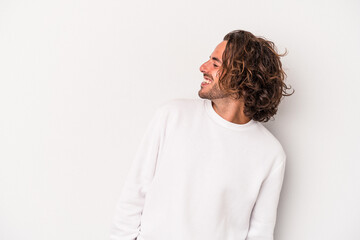 Young caucasian man isolated on gray background relaxed and happy laughing, neck stretched showing...