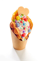 Bubble waffle ice cream with colorful candies isolated on a white background