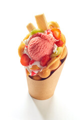 Bubble waffle ice cream with fresh fruits and berries on a white background