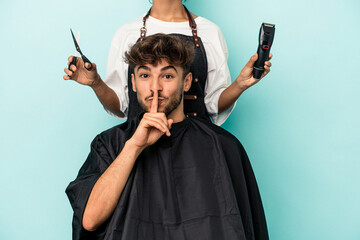 Young arab man ready to get a haircut isolated on blue background keeping a secret or asking for...