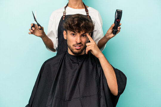 Young Arab Man Ready To Get A Haircut Isolated On Blue Background Showing A Disappointment Gesture With Forefinger.