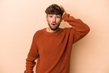 Young arab man isolated on beige background being shocked, she has remembered important meeting.