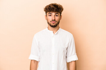 Young arab man isolated on beige background sad, serious face, feeling miserable and displeased.