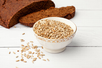 Rye bread with seeds lies on a light table. Seeds and crumbs
