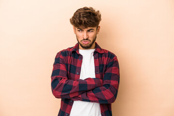 Fototapeta premium Young arab man isolated on beige background tired of a repetitive task.