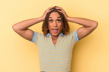Young latin transsexual woman isolated on yellow background screaming, very excited, passionate, satisfied with something.