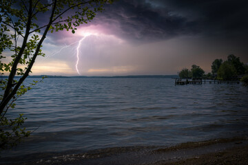 a big lightning from a thunderstorm strikes a lake