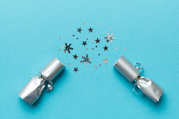 Christmas crackers with shiny confetti on color background, top view, copy space