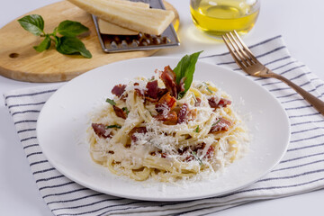 Pasta Carbonara. Spaghetti with bacon, parsel and parmesan cheese. Pasta Carbonara on white plate with parmesan. Italian food.