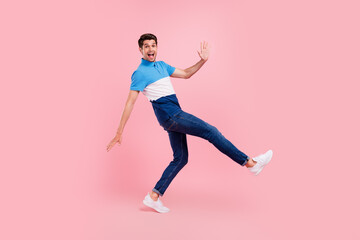 Fototapeta na wymiar Full size profile photo of sweet brunet millennial guy dance wave wear polo jeans sneakers isolated on pink background