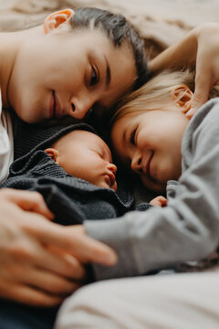 the mother lay down to sleep next to her daughters. Home photo of children with mom who fell asleep hugging