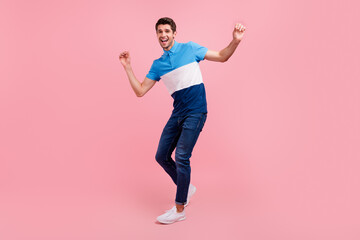 Full body photo of funky brunet millennial guy dance wear polo jeans sneakers isolated on pink background