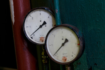 Old factory hall. Old measuring devices on the pipes of the thermal station.