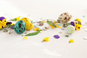 Modern Easter decor concept. Bright color quail eggs on white table