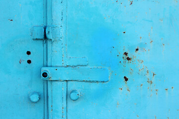 Rusty metal gates painted in blue paint. Entrance to the garage