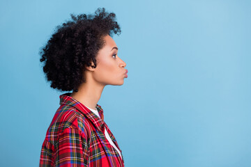 Profile side photo of young afro girl pouted lips send air kiss look empty space isolated over blue color background