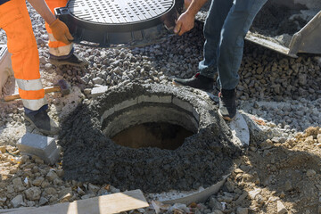 Obraz premium Construction of sewerage installing a sewer manhole on septic tank