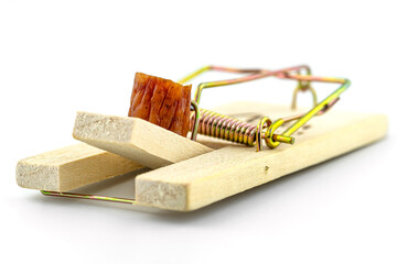 A macro photo of a piece of kabanosa meat lying on a pawl in a mousetrap, isolated on a white background.