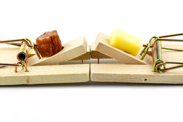 A macro photo of a cheese cube and a piece of kabanosa meat lying on a pawl in a mousetrap,...